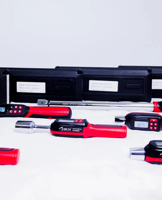 Set of red and black handheld Digital Torque Wrench set with display screens arranged on a surface in front of a black carrying case.